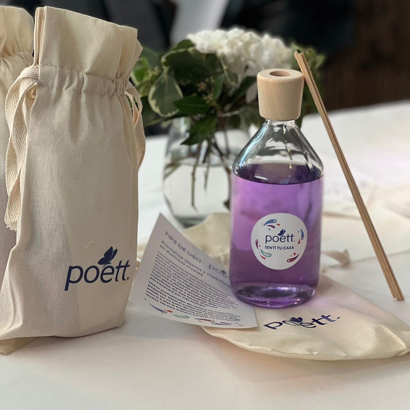 Bolsa de tela Poett junto a un difusor y piezas impresas de la marca